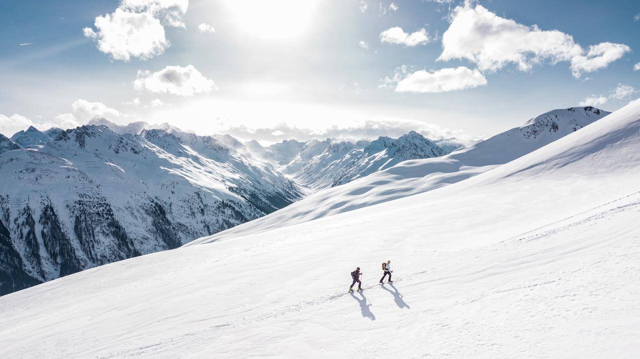 两个人在雪山上徒步旅行 4k风景高清壁纸